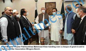 cm kp mahmood khan handling over a cheque to phc bar assocaition mangora