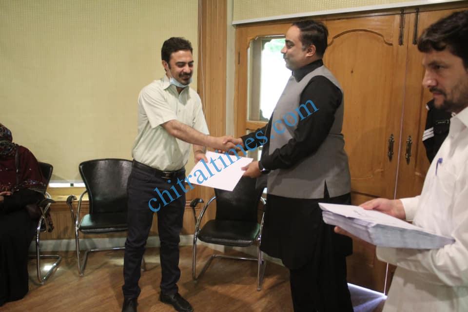 chitraltimes dc chitral hasan abid giving away certificate and prize to polio workers dr farman