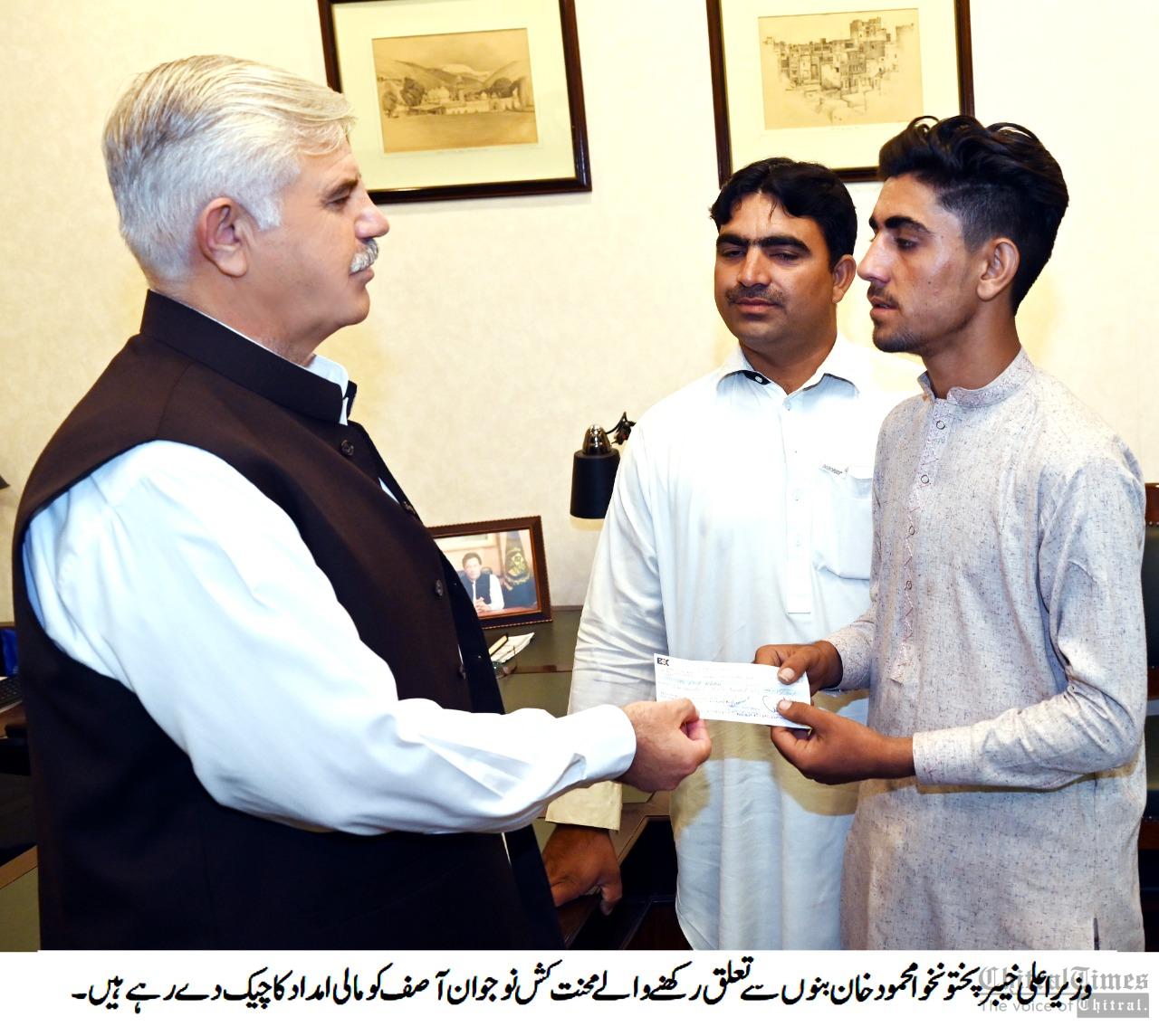 chitraltimes cm kpk giving cheque to asif of banu