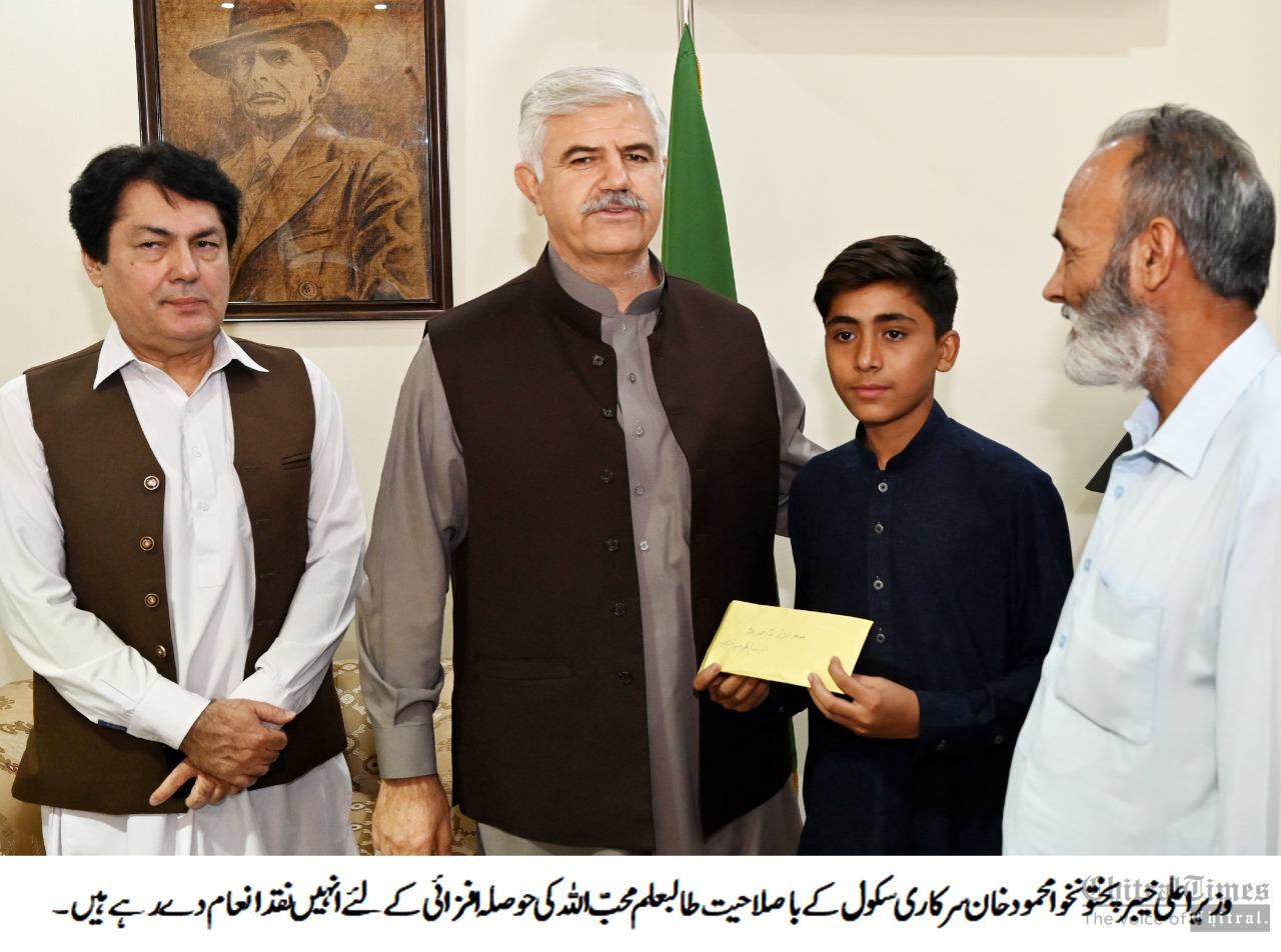 chitraltimes cm kpk giving cheque to a briliant student